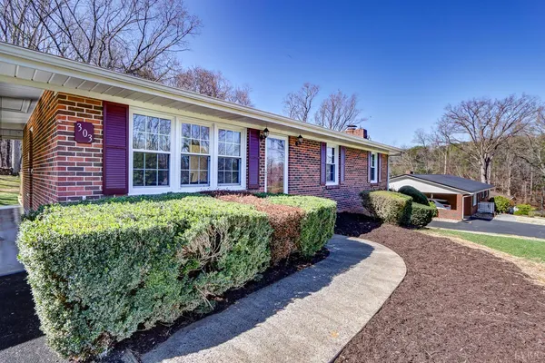 a front view of a house with a yard and trees