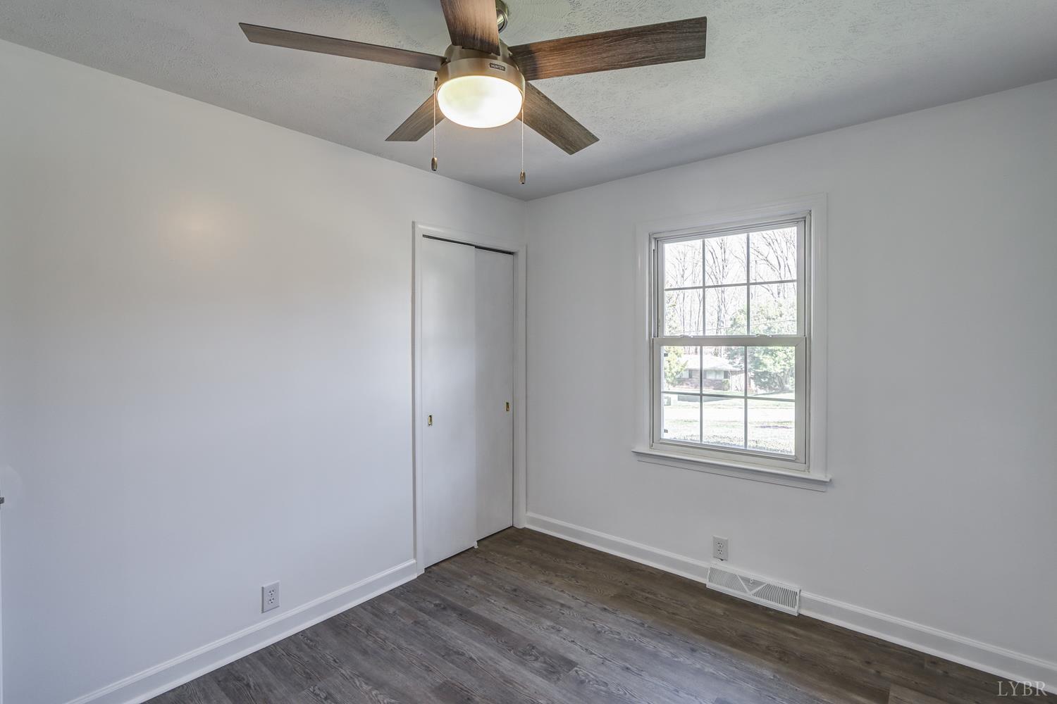 303 Grove Street Hurt, VA 24563 - Photo 27 of 51 an empty room with wooden floor ceiling fan and windows