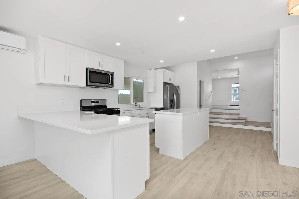 2157 Manchester Avenue Cardiff, CA 92007 - Photo 12 of 35 a kitchen with stainless steel appliances a stove a microwave a sink a refrigerator and white cabinets