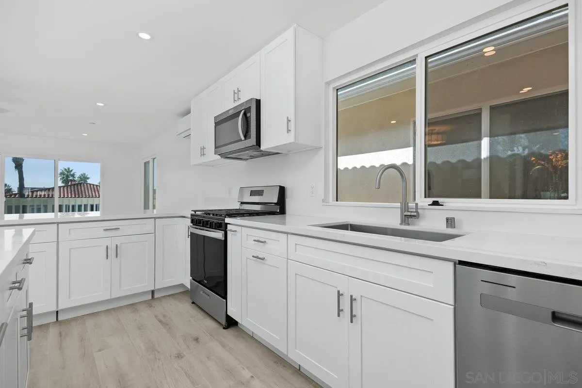 2157 Manchester Avenue Cardiff, CA 92007 - Photo 13 of 35 a kitchen with stainless steel appliances granite countertop white cabinets a sink and a window