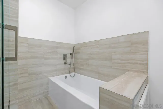 a bathroom with a bathtub and shower