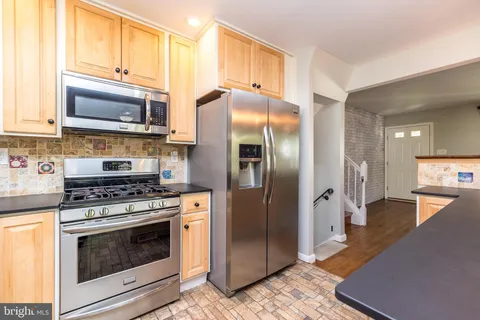 a kitchen with stainless steel appliances granite countertop a stove a refrigerator and a microwave
