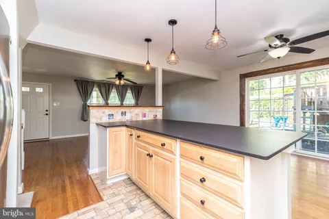 a kitchen with granite countertop a sink cabinets and wooden floor