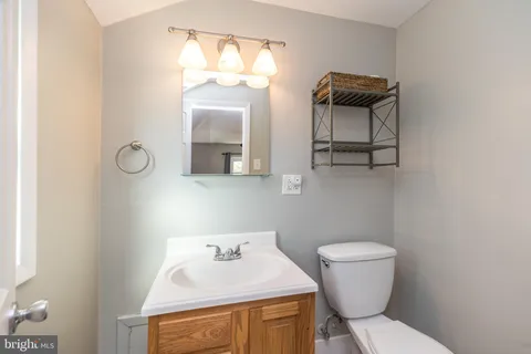 a bathroom with a toilet a sink and mirror