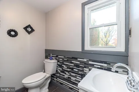 a bathroom with a sink a toilet and a window