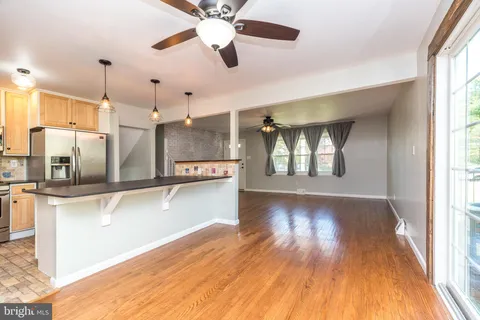 a view of a kitchen with wooden floor and a window