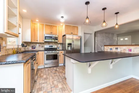 a kitchen with stainless steel appliances granite countertop a sink a stove and a refrigerator