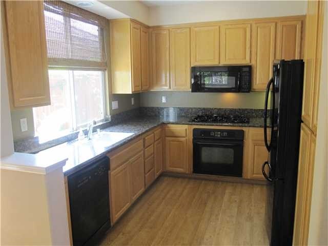 5426 Foxtail Loop Carlsbad, CA 92010 - Photo 2 of 15 a kitchen with stainless steel appliances granite countertop a stove a sink and a microwave