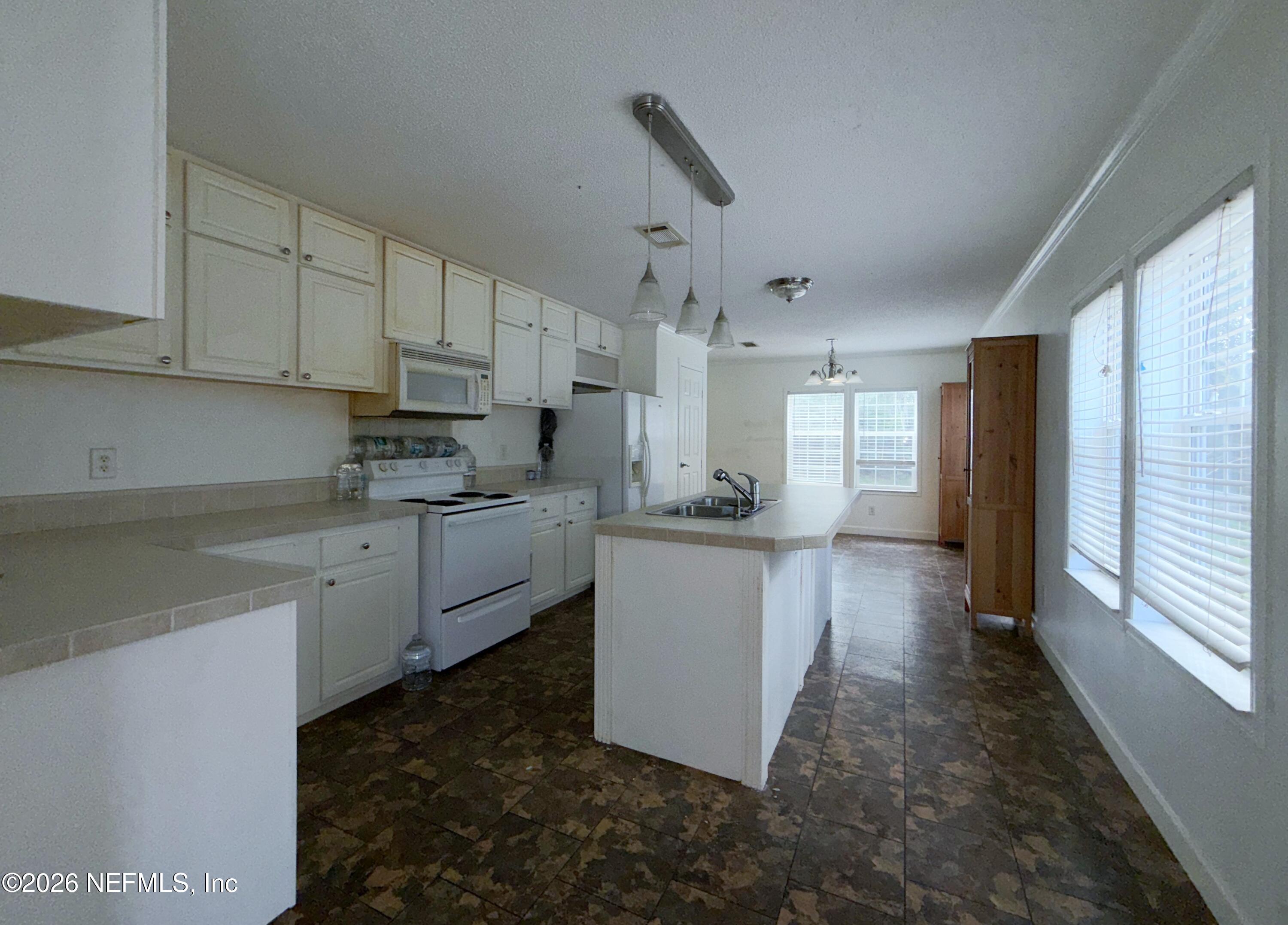 136 Short Pine Road Hawthorne, FL 32640 - Photo 14 of 39 a kitchen with white cabinets and white appliances