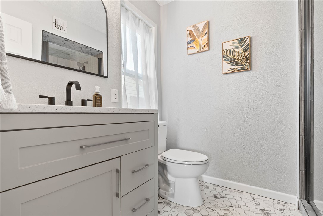 3211 Laguna Shores Road Corpus Christi, TX 78418 - Photo 15 of 29 a bathroom with a toilet sink vanity and mirror