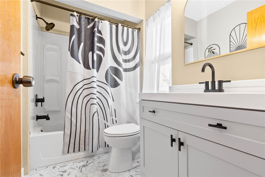 3211 Laguna Shores Road Corpus Christi, TX 78418 - Photo 20 of 29 a bathroom with a sink a mirror a toilet and a bathtub