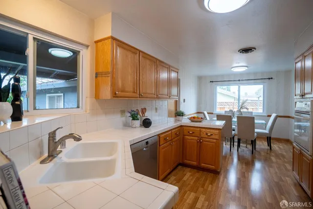 a kitchen with stainless steel appliances granite countertop sink stove refrigerator and cabinets