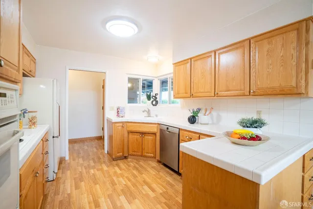 a kitchen with stainless steel appliances a sink a stove a refrigerator and cabinets