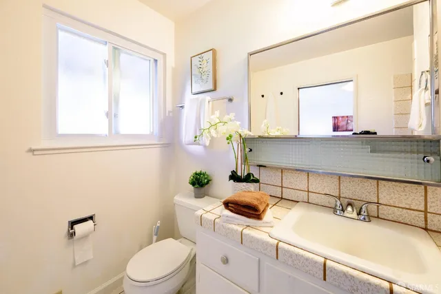 a white bath tub sitting next to a white sink and vanity