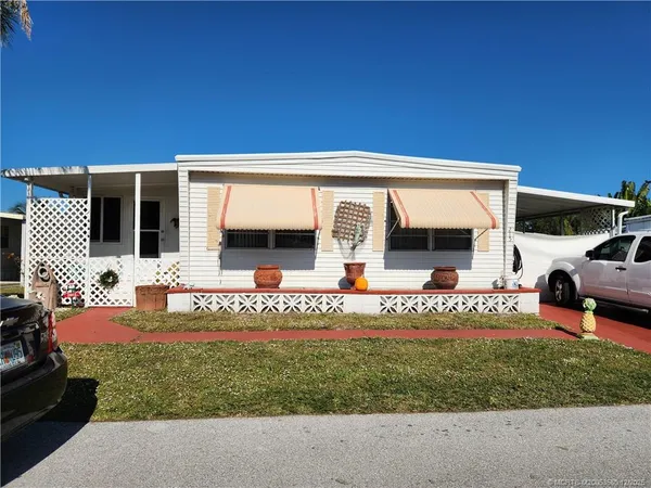 a front view of a house with a garden and sitting area