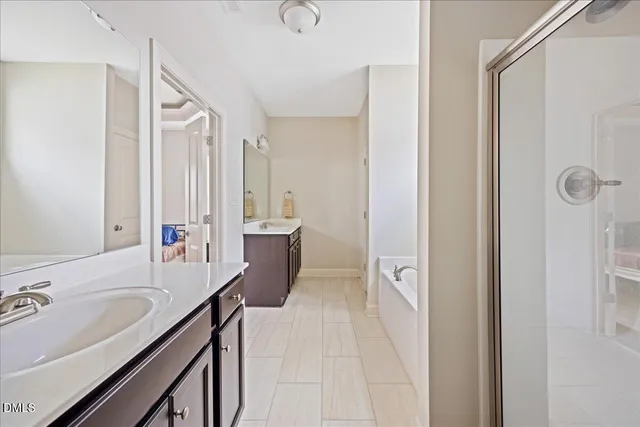 a spacious bathroom with a granite countertop sink a mirror and shower