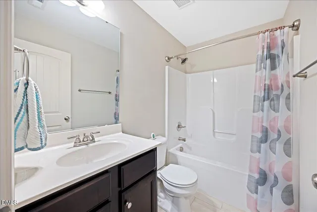 a bathroom with a sink toilet double vanity and shower