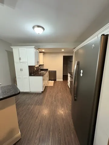 a view of a kitchen with wooden floor and electronic appliances
