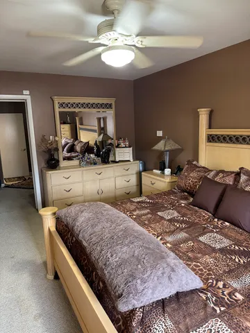 a bedroom with a large bed and a chandelier