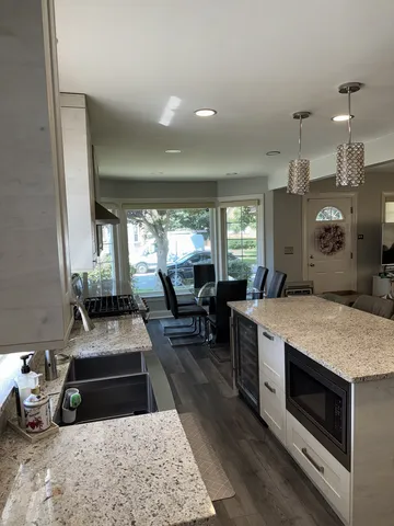 a large kitchen with stainless steel appliances granite countertop a stove and a granite counter tops with white cabinets