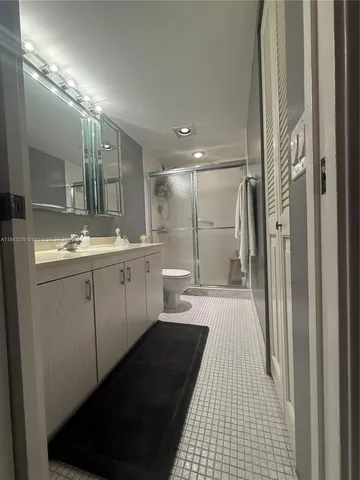 a bathroom with a double vanity sink toilet and a shower
