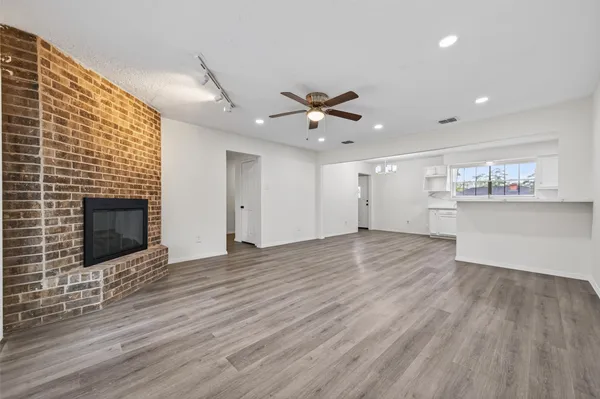 a view of an empty room with a fireplace and a window