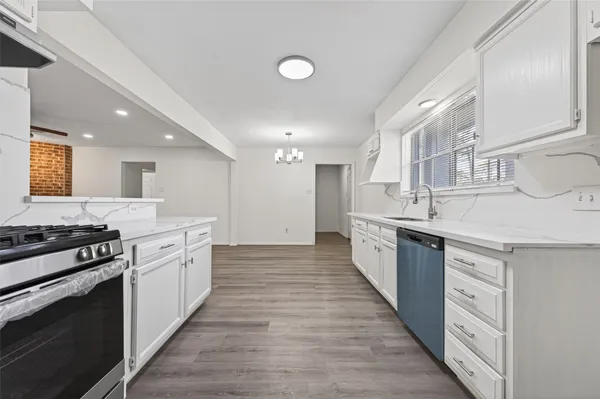 a large kitchen with stainless steel appliances granite countertop a stove and a sink
