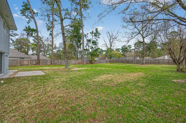 a view of a house with backyard and a tree