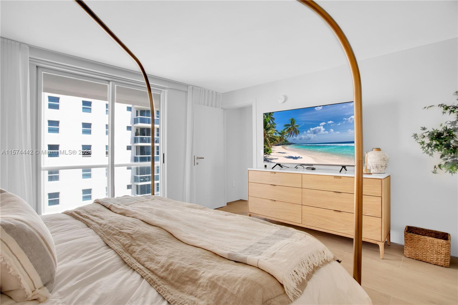 9195 Collins Avenue, Unit 903 Surfside, FL 33154 - Photo 23 of 51 a bedroom with a bed and a flat screen tv