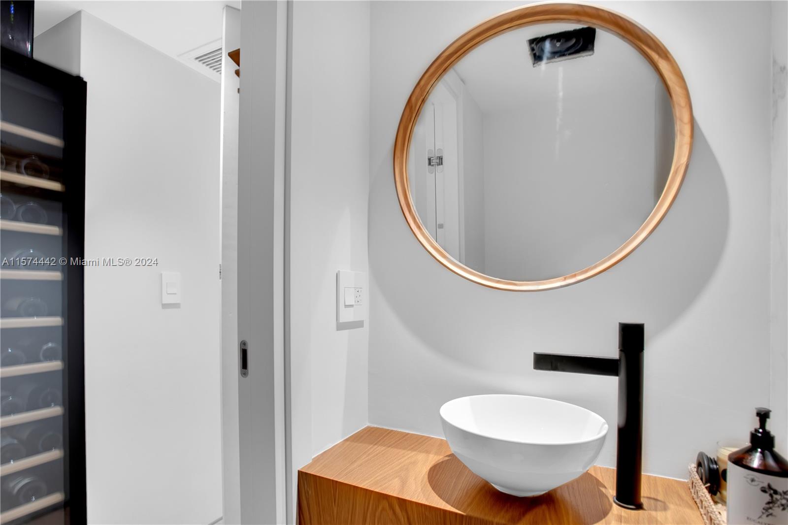 9195 Collins Avenue, Unit 903 Surfside, FL 33154 - Photo 36 of 51 a bathroom with a sink and a mirror