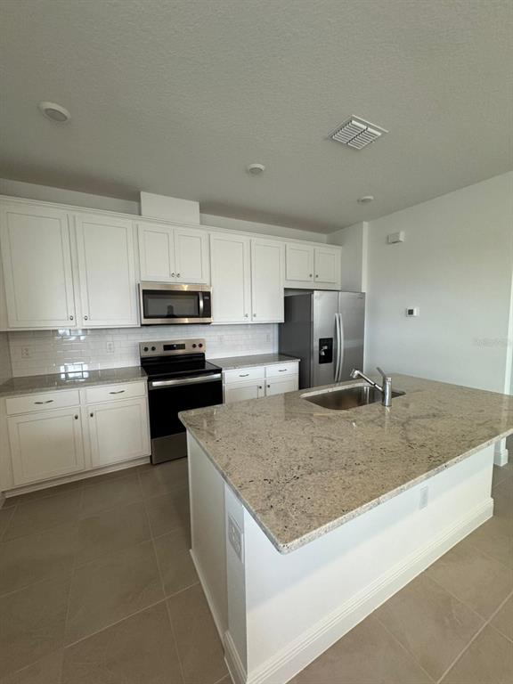 10070 Fiddley Alley Orlando, FL 32827 - Photo 4 of 10 a kitchen with stainless steel appliances granite countertop a sink stove and refrigerator