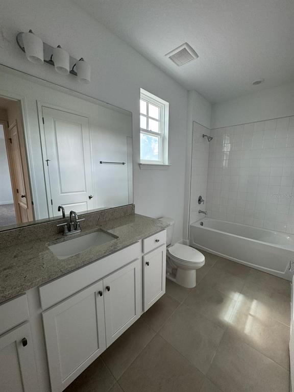 10070 Fiddley Alley Orlando, FL 32827 - Photo 7 of 10 a bathroom with a granite countertop sink a toilet and a mirror