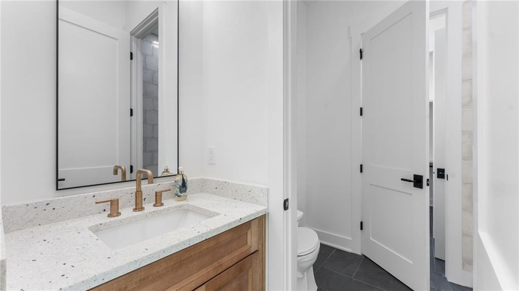 165 Highlands Chase Ball Ground, GA 30107 - Photo 21 of 40 a bathroom with a granite countertop sink toilet and shower