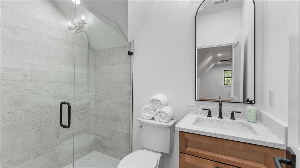 165 Highlands Chase Ball Ground, GA 30107 - Photo 28 of 40 a bathroom with a granite countertop sink a toilet and a mirror