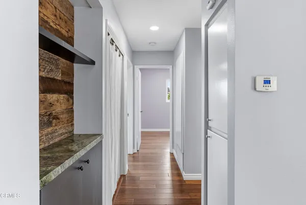 a view of hallway with stairs and wooden floor