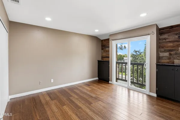 a view of an empty room with wooden floor
