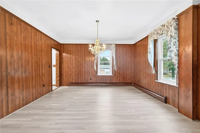 a view of an empty room with wooden floor and windows