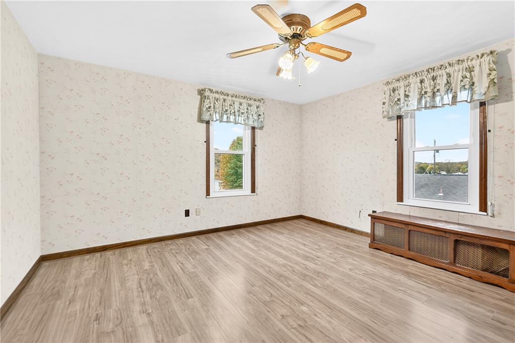 815 Washington Road Belle Vernon, PA 15012 - Photo 27 of 50 an empty room with wooden floor chandelier fan and windows