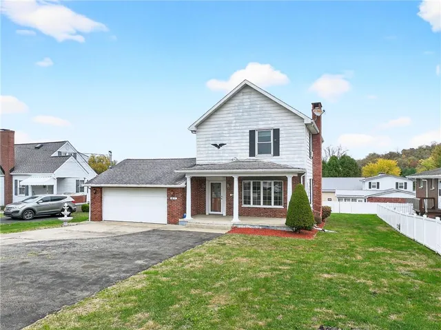a front view of a house with a garden and yard