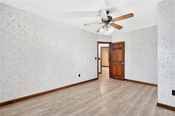 a view of an empty room with window and wooden floor