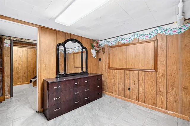 a spacious bedroom with a dresser and a mirror