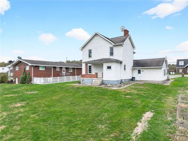 a view of a house with a yard and sitting area