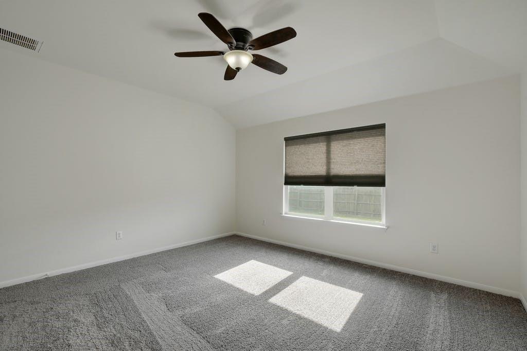 173 Rafe Court Kyle, TX 78640 - Photo 13 of 27 Spare room featuring ceiling fan, light carpet, and lofted ceiling