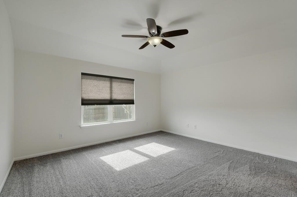 173 Rafe Court Kyle, TX 78640 - Photo 14 of 27 Carpeted empty room featuring baseboards and a ceiling fan