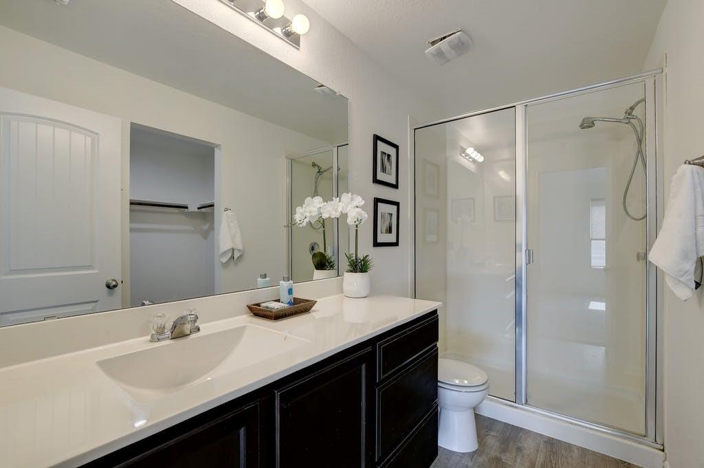 173 Rafe Court Kyle, TX 78640 - Photo 16 of 27 Full bathroom with a shower stall, vanity, and dark wood-type flooring