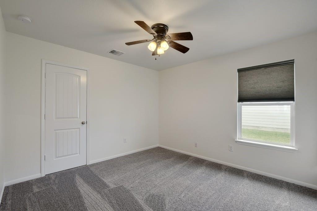 173 Rafe Court Kyle, TX 78640 - Photo 17 of 27 Empty room featuring dark carpet and a ceiling fan