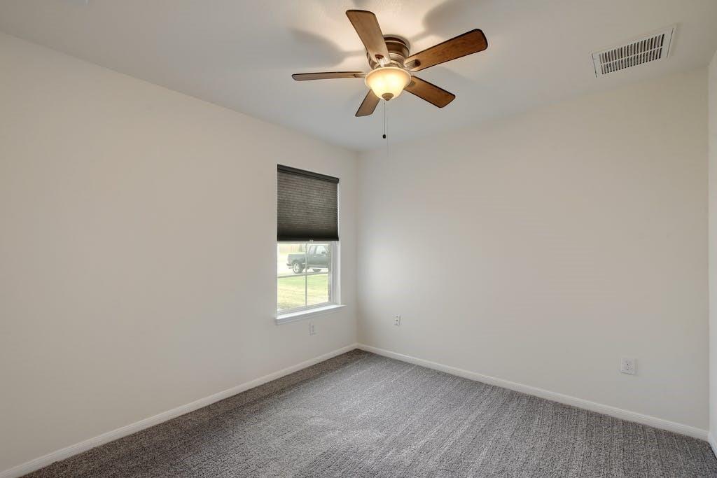 173 Rafe Court Kyle, TX 78640 - Photo 20 of 27 Carpeted empty room with ceiling fan and baseboards