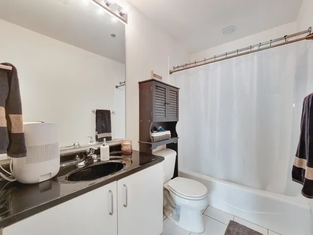 a bathroom with a sink a toilet and shower curtain