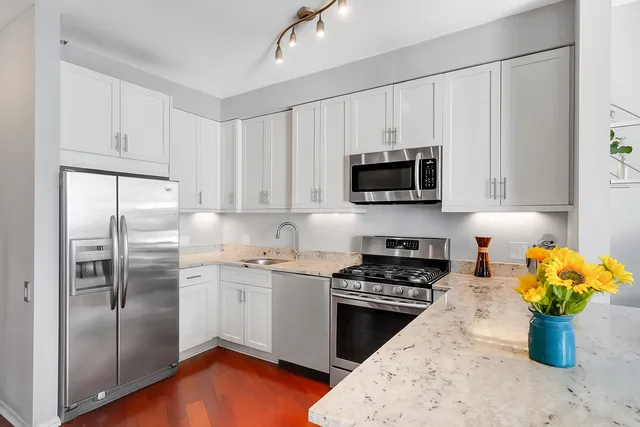 a kitchen with a refrigerator and a stove top oven