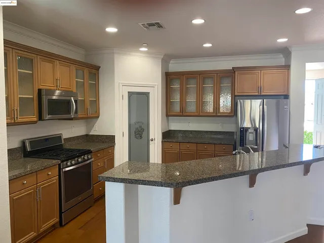 a kitchen with granite countertop stainless steel appliances and sink